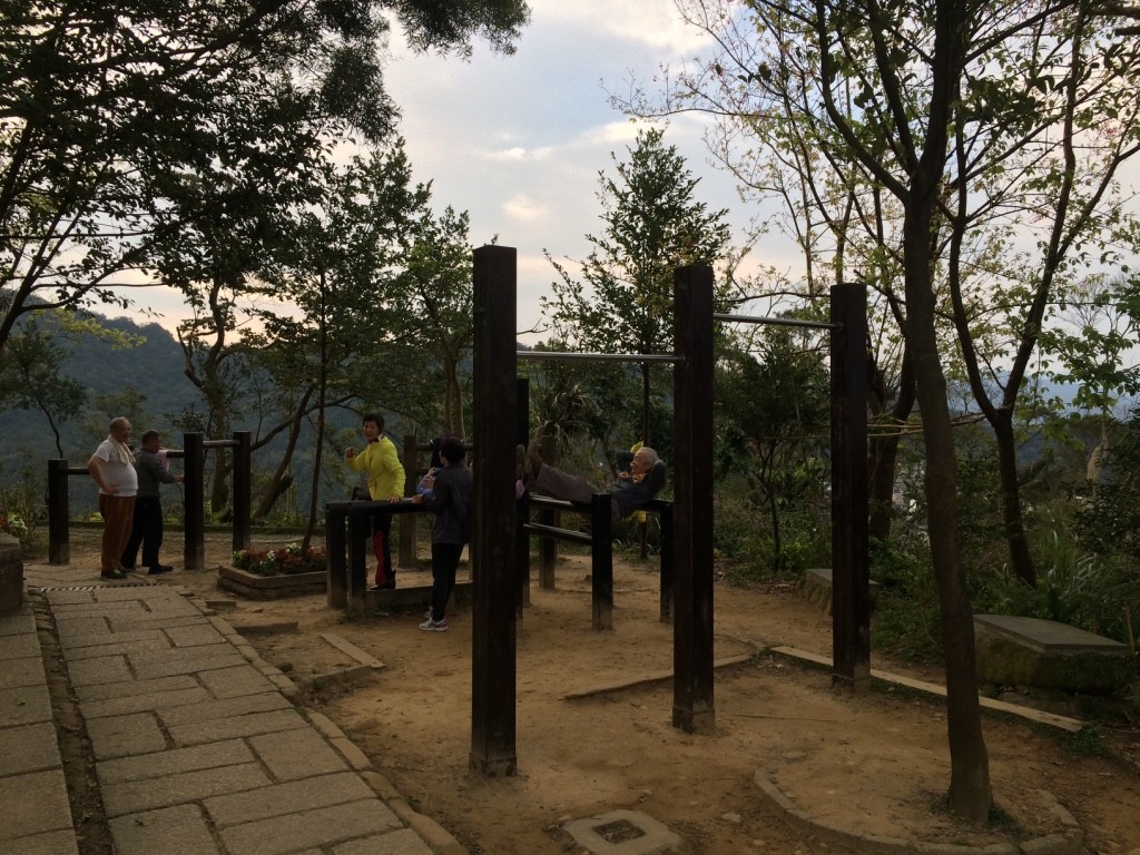 Old man doing curl ups. It seemed like all these people were regulars who climbed up the mountain and met here to do their daily workouts.