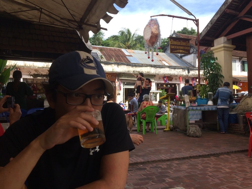 Tim drinking his Beer Lao while I watch what's going on in the background