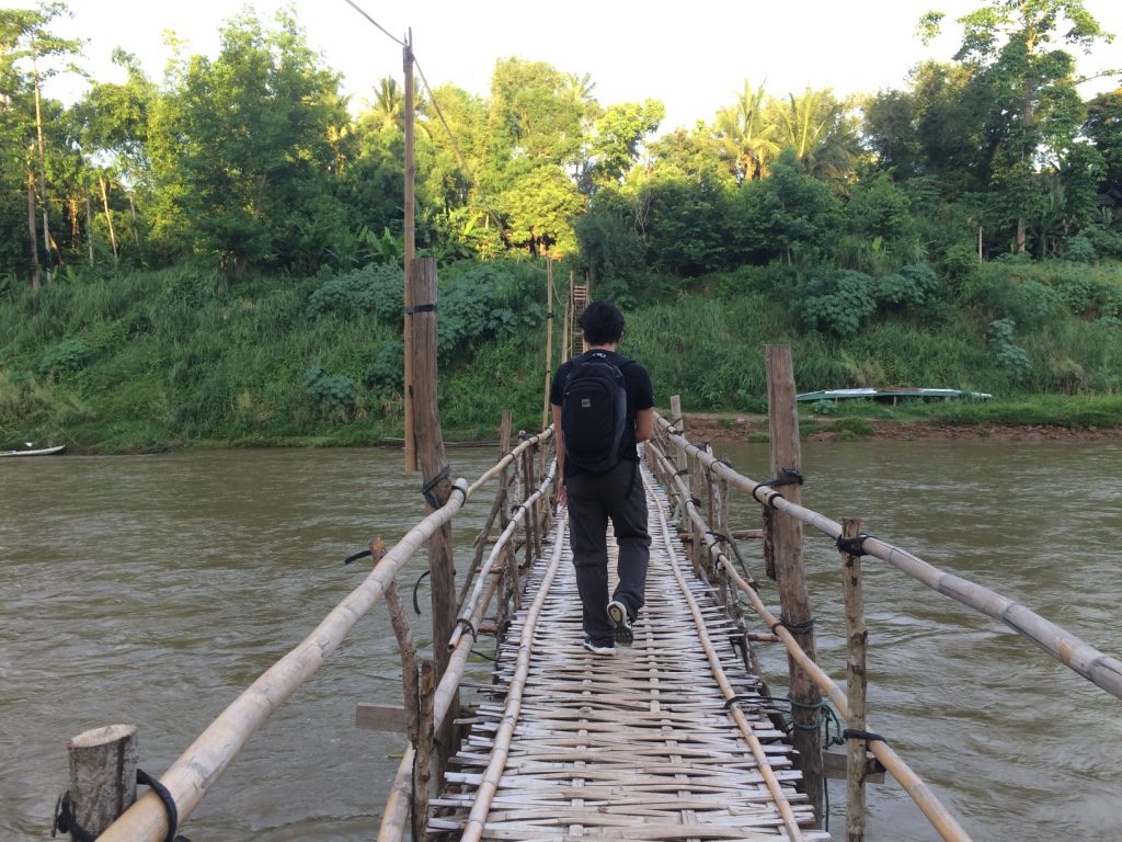 Tim crossing the bamboo bridge