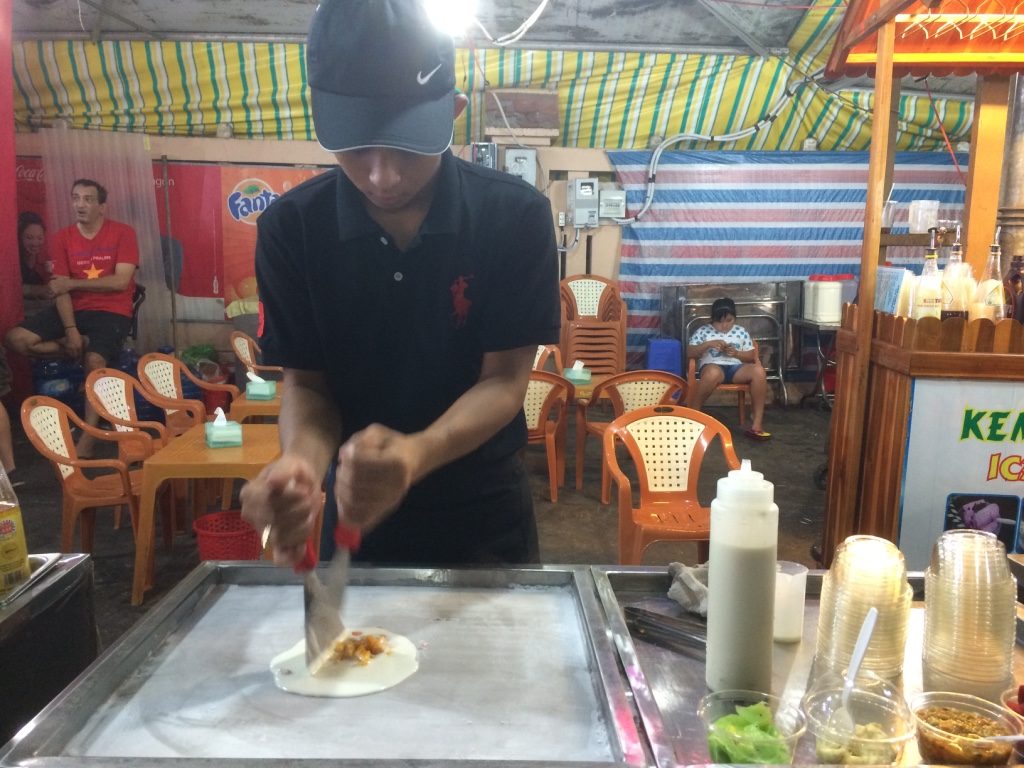 Thai rolled mango ice cream. He minces up mango and pours liquid milk on top and mixes it up.